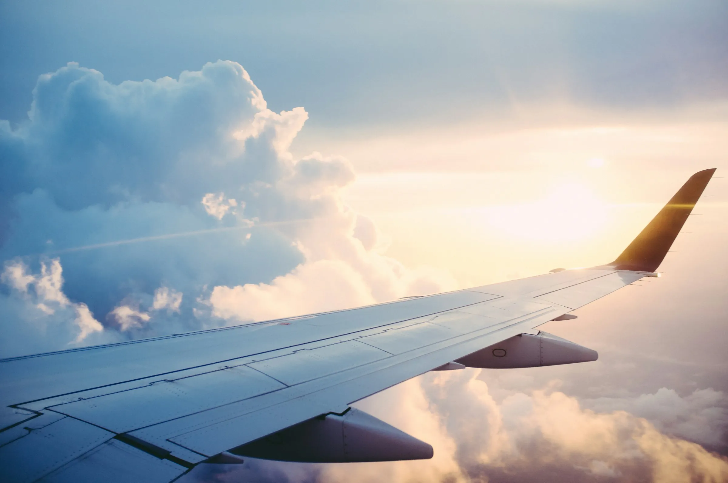Ala de avión sobre un mar de nubes al amanecer
